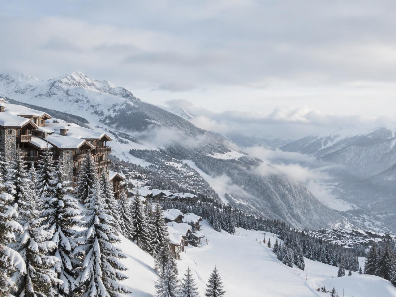 Snow-covered Courchevel chalets on a winter alpine slope